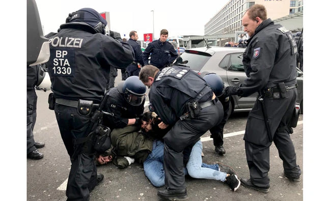German police arrests a protestor during clashes following a demonstration against Turkey's offensive against Kurds in Syria's Afrin region, in this March 11, 2018 photo, at the airport in Duesseldorf. (AFP)
