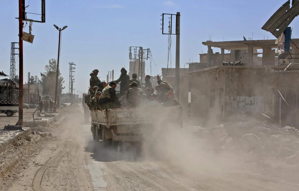 Syrian government soldiers ride in the back of a truck advancing in the town of Al-Mohammadiyeh, east of the capital Damascus on March 7, 2018, as Syrian government forces push into the rebel-held eastern Ghouta enclave. (AFP)