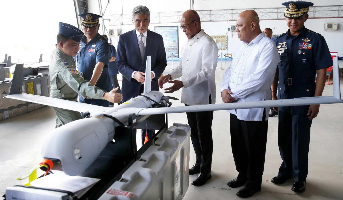 US Ambassador to the Philippines Sung Kim, third from left, and Philippine Defense Secretary Delfin Lorenzana, third from right, are briefed on the features of the ScanEagle Unmanned Aerial Vehicles during its turnover Tuesday at Villamor Air Base in suburban Pasay city southeast of Manila. (AP)