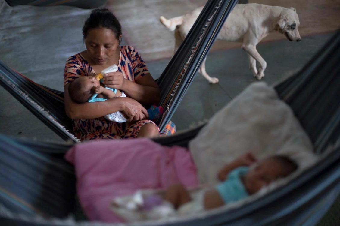 In this file photo taken on February 24, 2018 Venezuelan Warao indigenous woman Yulen Moraleda, 33, gives milk to one of her new-born twins at the Pintolandia shelter in the city of Boa Vista, Roraima, Brazil, on February 24, 2018. (AFP)