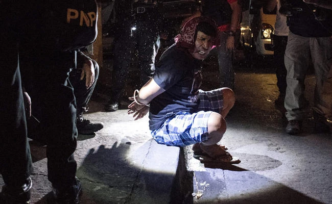 Philippine Drug Enforcement Agency (PDEA) agents and police arrest an alleged drug dealer during a drug raid in Maharlika Village, Taguig, south of Manila on February 28, 2018. (AFP)