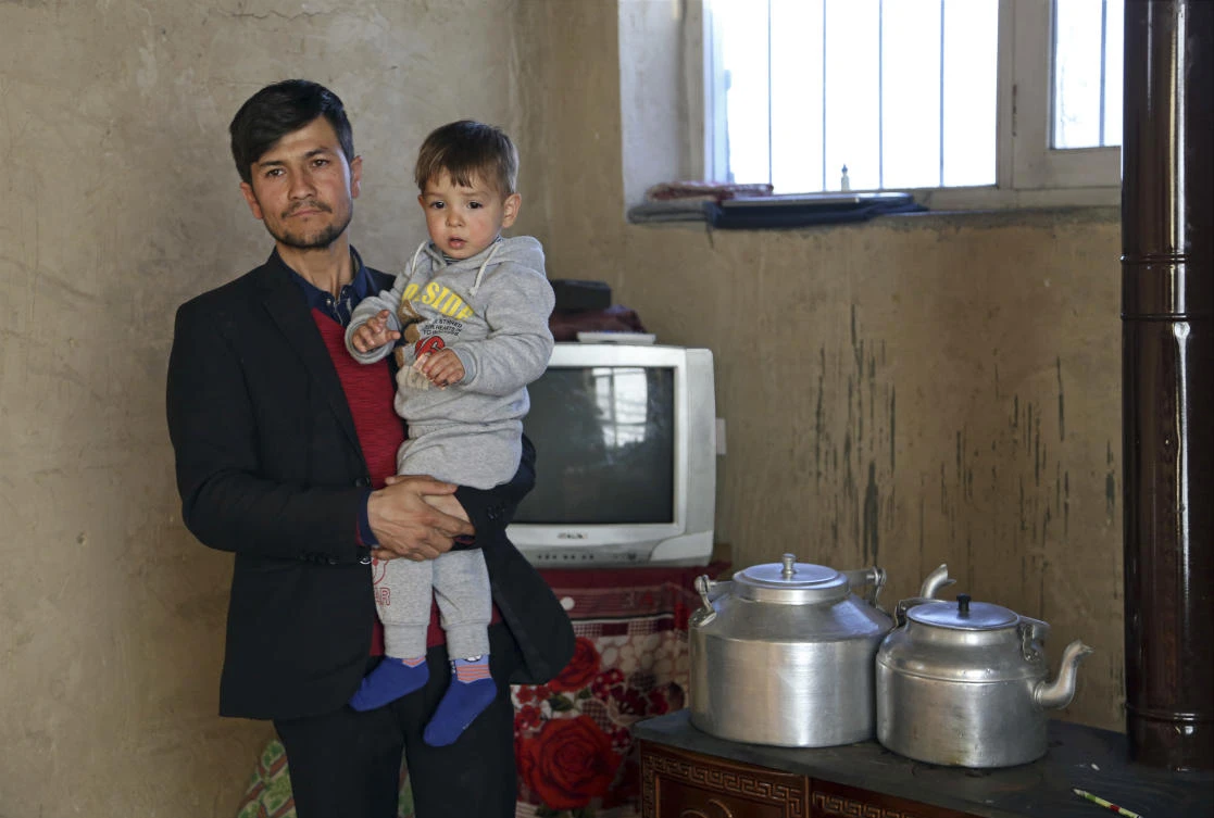 Asadullah Poya with his 18-month-old son Donald Trump, poses for a photograph at their rented house in Kabul, Afghanistan, Mar 15, 2018. (AP)