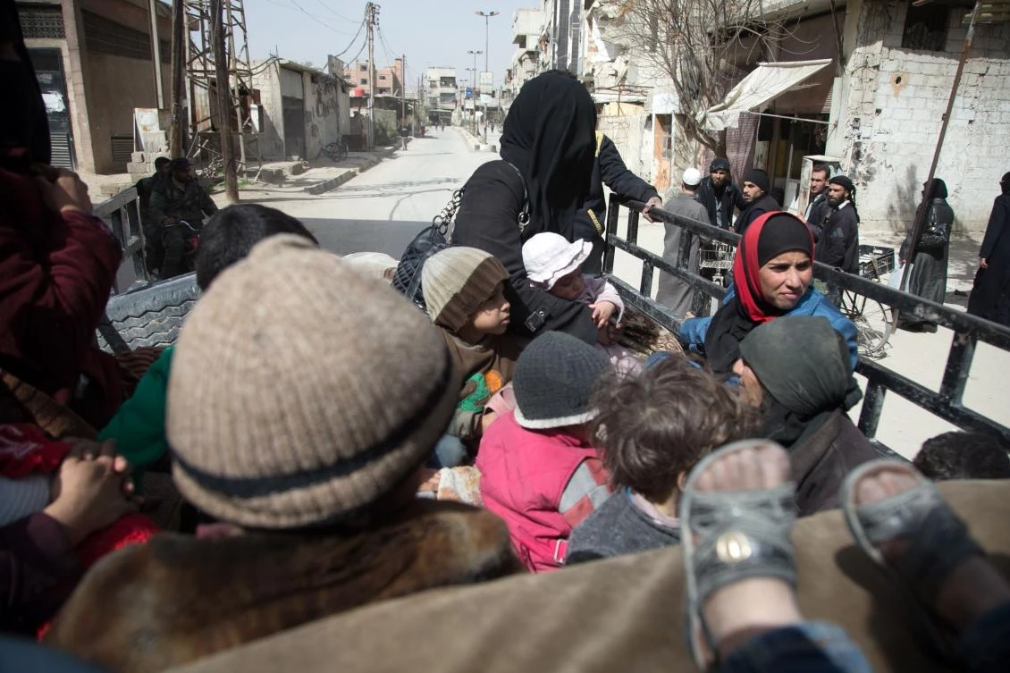 Syrians sit in the back of a truck ,driven by White Helmets, as they try to flee their homes in the town of Hamouria in Syria's besieged eastern Ghouta. (AFP)