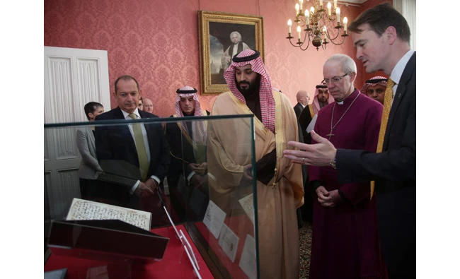 Britain's Archbishop of Canterbury Justin Welby shows The Crown Prince of Saudi Arabia Mohammed bin Salman the Birmingham Quran as UK’s ambassador to the Kingdom, Simon Collis, looks on.