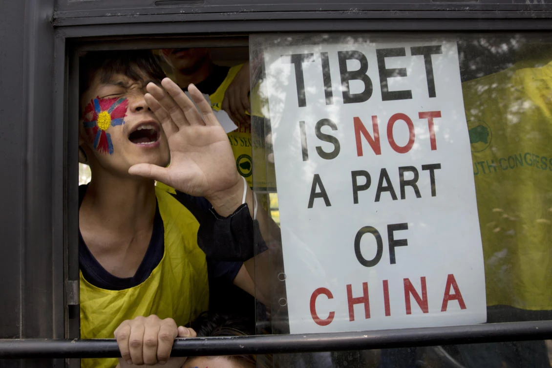 An exile Tibetan shout slogans as he is being taken to a police station in a bus during a protest outside the Chinese Embassy, in New Delhi, India, Friday, March 9, 2018. (AP)