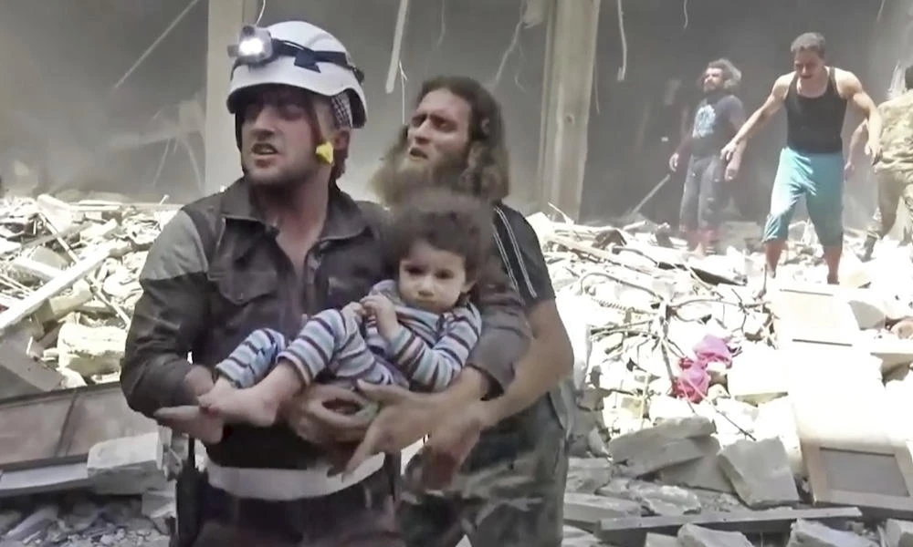 A civil defense worker carries a child after airstrikes hit Aleppo, Syria. With Russia's help, the government forces of President Bashar Assad finally seized rebel-held portions of the city of Aleppo, at a huge cost in terms of deaths and destruction. (AP)