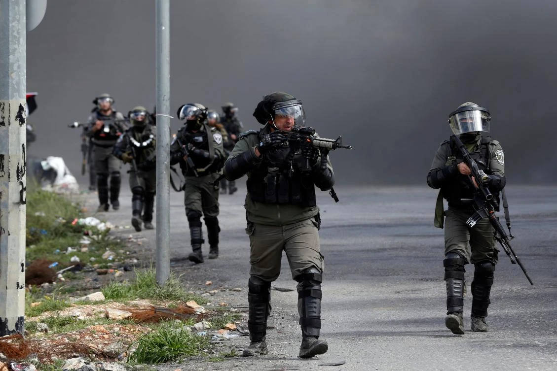This file photo shows Israeli border guards advance down a street during clashes with Palestinian protesters following a demonstration in the West Bank city of Ramallah on March 9, 2018 against a decision by US President Donald Trump to recognize Jerusalem as the capital of Israel. (AFP)