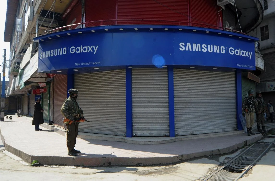 Indian paramilitary personnel stand guard along a road during a curfew the day after six people were killed in a shutout in Shopian district, in Srinagar on March 5, 2018. (AFP/Habib Naqash)