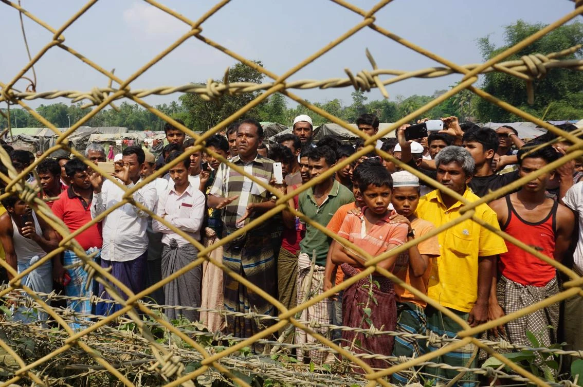 Minority Rohingya Muslims gather behind Myanmar’s border lined with barbed wire fences in Maungdaw district, located in Rakhine State bounded by Bangladesh on March 17, 2018. Rohingya holed-up in “no-man’s land” between Bangladesh and Myanmar on Sunday said they will only return to their old villages in Rakhine state and not via transit camps where they fear long-term confinement. Some 700,000 Rohingya have been driven into Bangladesh since August last year by a major Myanmar army crackdown to “clear” northern Rakhine state of militants from the Muslim minority (AFP/Joe Freeman)