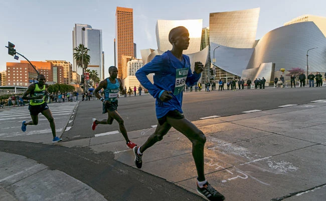 Los Angeles Marathon Elite runners, from left, Weldon Kirui, Simon Njoroge, Elisha Barno race past the Walt Disney Concert Hall in Los Angeles Sunday, March 18, 2018. Kirui won the Los Angeles Marathon with an unofficial time of 2 hours 11 minutes and 47 seconds. (AP Photo/Damian Dovarganes)