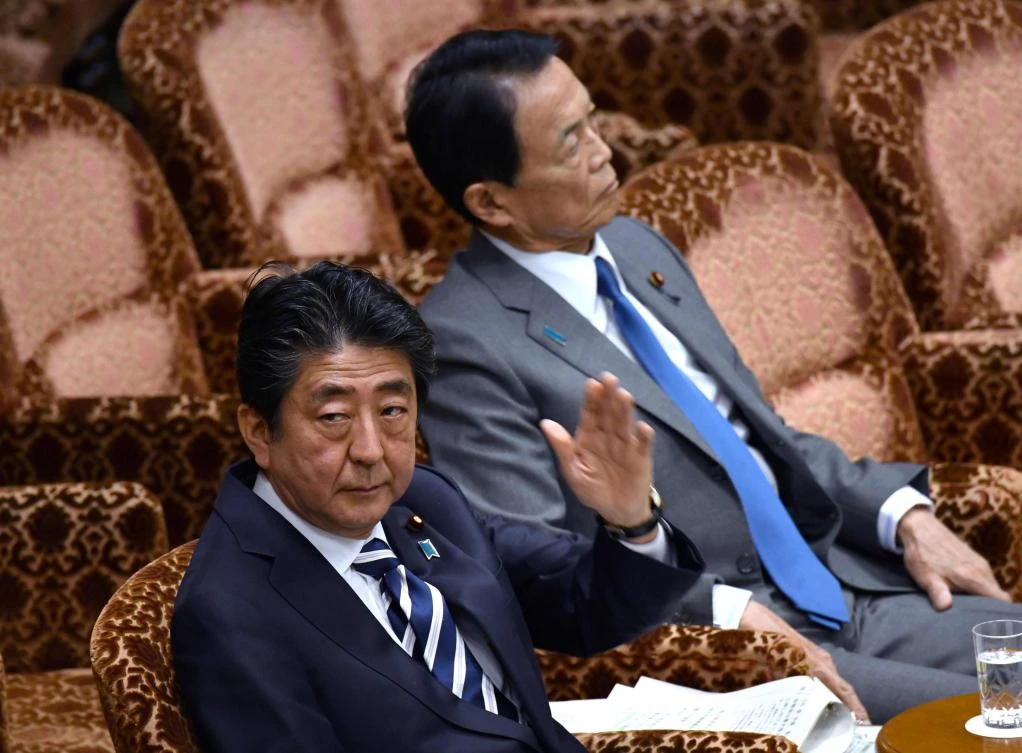 Japan’s Prime Minister Shinzo Abe, bottom, raises his hand to answer questions during a budget committee session of the upper house in Tokyo on Monday, March 19. Abe hit back at critics over a favoritism and cover-up scandal that has seen his popularity suffer. (AFP)