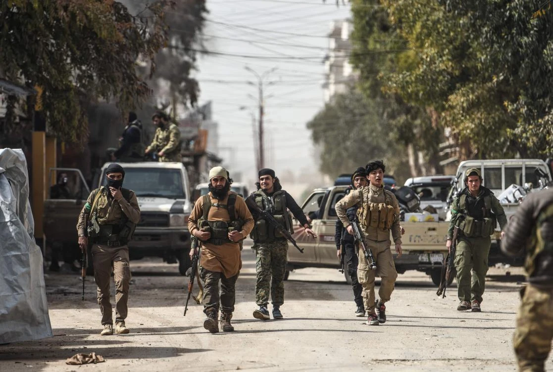 Turkish-backed Syrian Arab fighters walk in the streets after seizing control of the northwestern Syrian city of Afrin from the Kurdish People’s Protection Units (YPG) on March 18, 2018. (AFP)