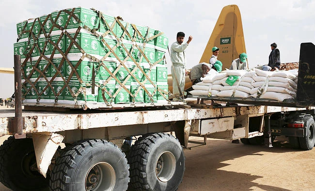 In this Feb. 3, 2018 photo, a relief worker signals a forklift driver unloading aid carried into Yemen by the Saudi military in Marib, Yemen. (AP)
