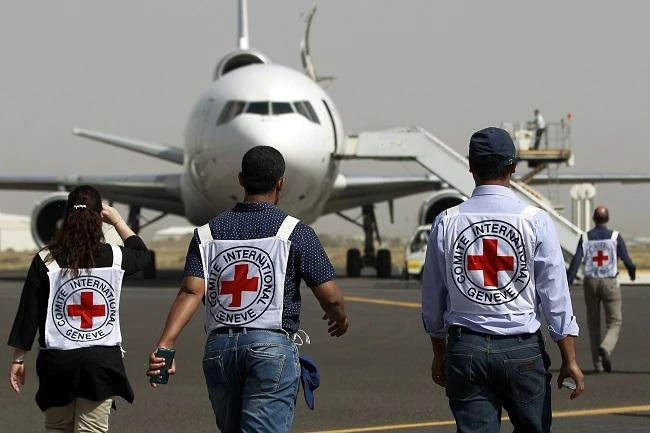 Members of the International Committee of the Red Cross walk towards a plane loaded with Emergency medical aid. (AFP)