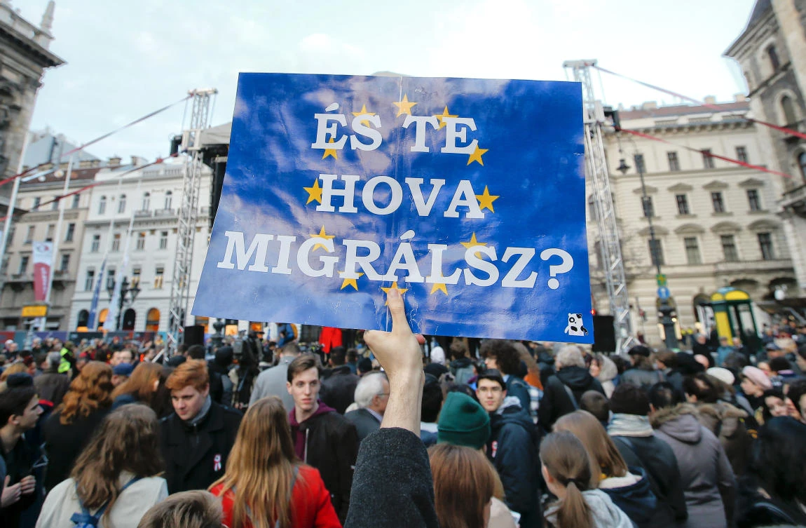 A man taking part in a march against Prime Minister Viktor Orban holds a holds a banner that reads "Where are you migrating" on the background of the European Union flag, in Budapest, Hungary, Thursday, March 15, 2018.(AP)