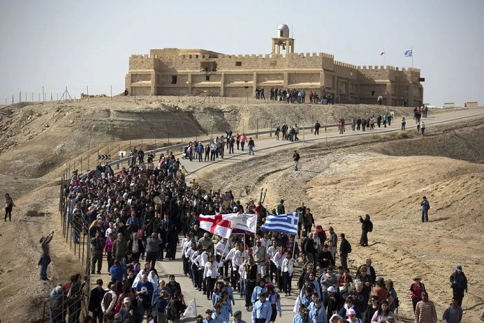 Christian Orthodox pilgrims march towards the Jordan River from the Greek Orthodox monastery of St John the Baptist before a baptism ceremony at Qasr Al-Yahud as part of the Feast of the Epiphany in the West Bank. The HALO Trust has begun work to clear about 3,000 pieces of ordnance scattered around the holy site. (AFP)