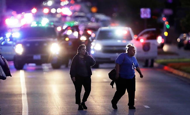 People evacuate as emergency vehicles stage near the site of another explosion, Tuesday, March 20, 2018, in Austin, Texas. (AP)