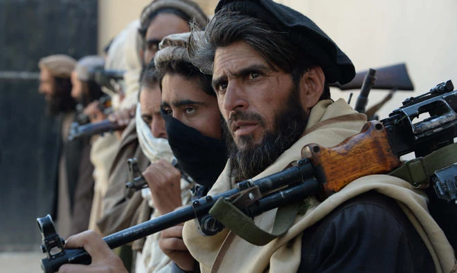 In this file photo, Afghan alleged former Taliban fighters carry their weapons before handing them over as part of a government peace and reconciliation process at a ceremony in Jalalabad on Feb. 24, 2016. (AFP)