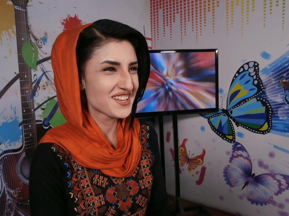 Krishman Naz smiles during the recording of her program inside a studio of Zan TV in Kabul. (Photo by Sayed Salahuddin)