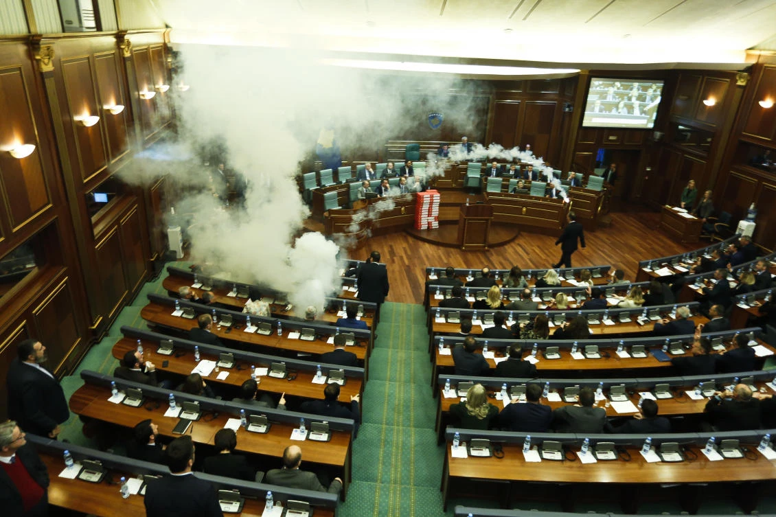 Opposition lawmakers throw a tear gas canister disrupting a parliamentary session in Kosovo capital Pristina on Wednesday, March 21, 2018. Kosovo's Parliament, has temporarily suspended its session after tear gas disrupted the vote on a border demarcation deal with Montenegro. (AP)