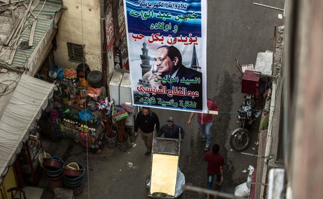 A picture taken on March 7, 2018 shows posters supporting Egyptian President Abdel Fattah El-Sisi hanging in a street in the downtown Cairo district of El-Gamaleya, where he was born. (AFP / KHALED DESOUKI)