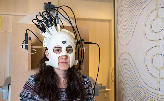 A handout photo released on March 21, 2018 via Nature from Wellcome shows a woman with a brain scanner. (AFP PHOTO / NATURE / WELLCOME)