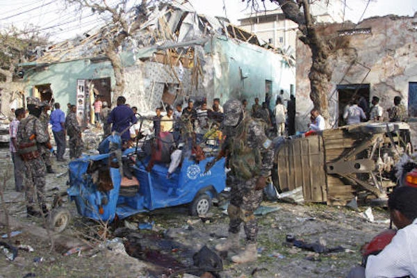 Somalis stand outside a destroyed building after a car bomb in Mogadishu, Somalia Thursday, Mar. 22, 2018. (AP)