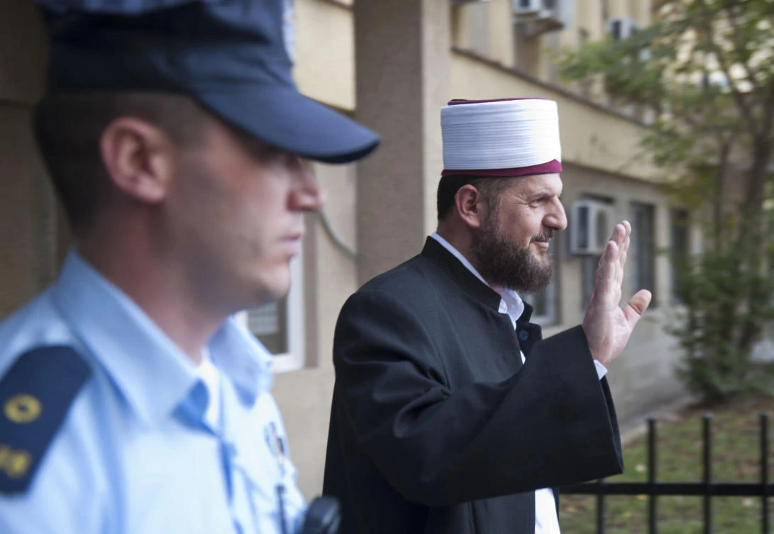 This file image shows Kosovo’s top radical cleric, the imam of the Grand Mosque in Pristina, Shefqet Krasniqi is escorted by a Kosovo police officer as he leaves the court in September 2014 in Pristina. (AFP /Armend Nimani)