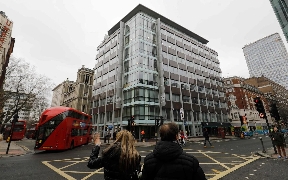 Pedestrians cross the road near outside the shared building which houses the offices of Cambridge Analytica in central London on March 24, 2018. (AFP)