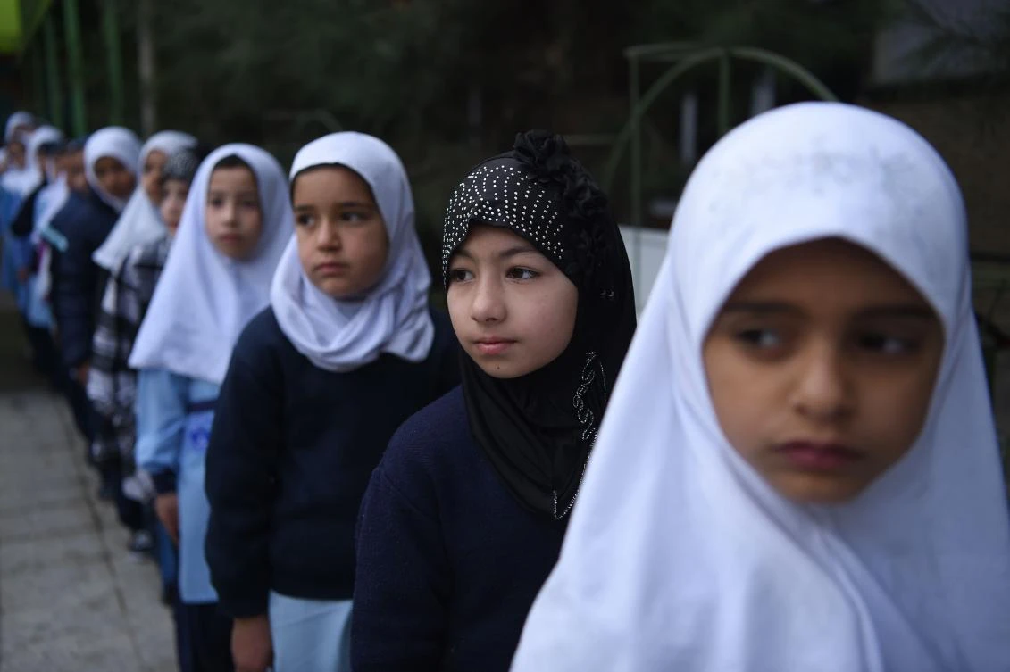 This picture taken on March 24, 2018 shows Afghan schoolgirl Dunya (2nd R), 8, standing in line with other students on the first day of the school year in the courtyard of a private school in Kabul. This weekend marks the beginning of the Afghan school year, but in war-torn Afghanistan the routine of getting children to and from school is often fraught with danger. (AFP/Wakil Kohsar)