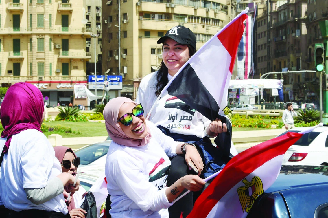 Women wave national flags as they celebrate in Cairo’s Tahrir square on Monday on the first day of voting in the presidential election. (AFP)