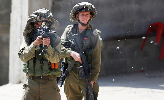 Israeli soldiers on Tuesday detained three Palestinians who slipped across the border with the Gaza Strip in possession of knives and grenades. (AP)
