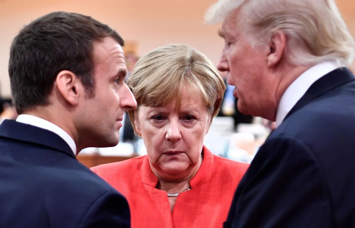 (L-R) French President Emmanuel Macron, German Chancellor Angela Merkel and US President Donald Trump confer at the start of the first working session of the G20 meeting in Hamburg, northern Germany. (AFP)