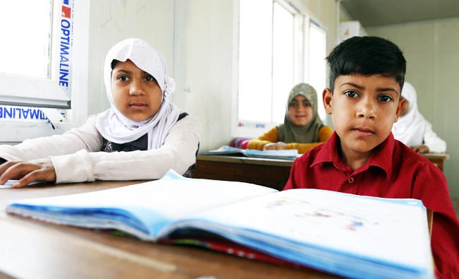 Iraqi Roma children attend a class, after many years of not going to school, in the village of Al-Zuhour in Iraq's Diwaniya province, 200 kilometres south of Baghdad on March 25, 2018. (AFP)