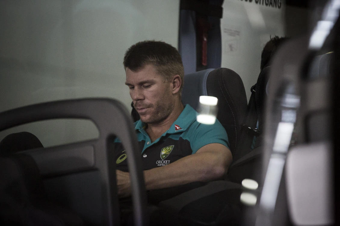Former vice-captain David Warner of the Australian Cricket Team sits in the shuttle bus as he arrived at OR Tambo International Airport after the team was caught cheating in the Sunfoil Test Series between between Australia and South Africa on March 27, 2018. (Gulshan Khan/AFP)