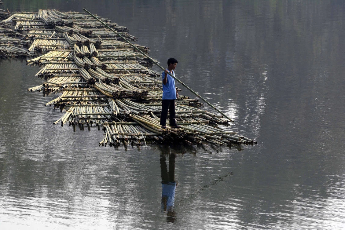 An Indian laborer pushes heaps of bamboo on a river to be sold at a floating market – and set to be used in the construction industry – in Chakmaghat, some 56km north of Agartala, the capital of northeastern state of Tripura. (Arindam Dey/AFP)
