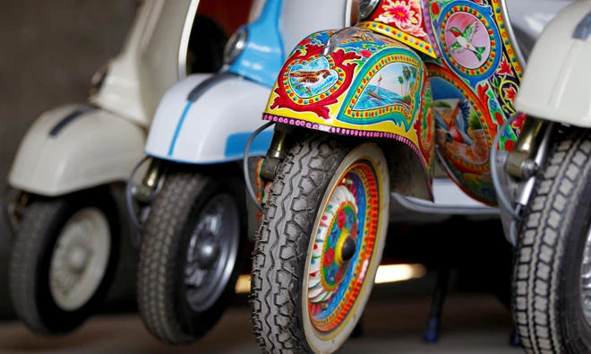 A restored Vespa scooter painted in Pakistani truck art style, is parked alongside traditionally-coloured scooters at a Vespa restoration and repair workshop in Islamabad, Pakistan on Feb. 27, 2018. (REUTERS)