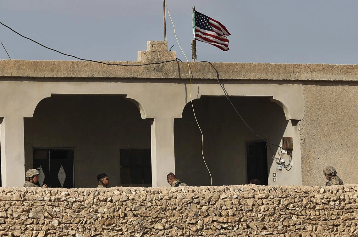 US soldiers sit on a house that turned to an outpost on a road leading to the tense front line between U.S-backed Syrian Manbij Military Council fighters and Turkish-backed fighters, at Halawanji village, north of Manbij town, Syria. (AP)