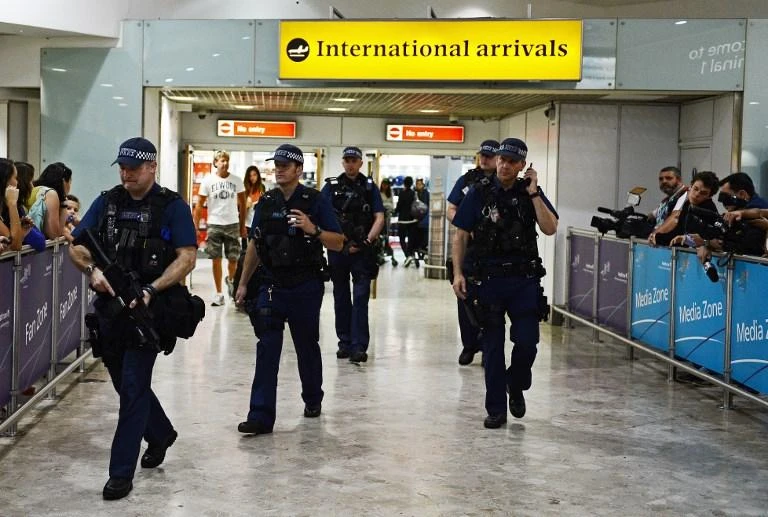 File photo showing armed police officers walk in front of the arrival gate at Heathrow airport. (AFP)
