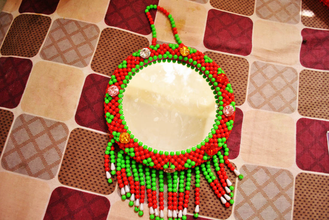 Young girls decorated this mirror with small colorful beads. (AN photo by Saba Rehman)