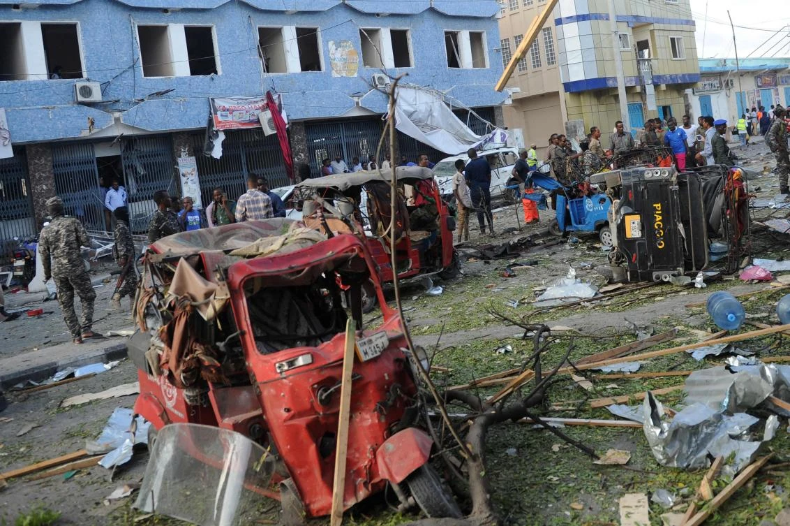 People gather near damaged vehicles after a car bomb blew up outside the Weheliye hotel in Mogadishu on March 22, 2018. (File Photo: AFP)