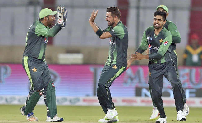 Pakistani pacer Mohammad Amir, center, celebrates with teammates after taking wicket of West Indies batsman Andre Fletcher during their 1st T20 cricket match at National stadium in Karachi, Pakistan on April 1, 2018. (AP)