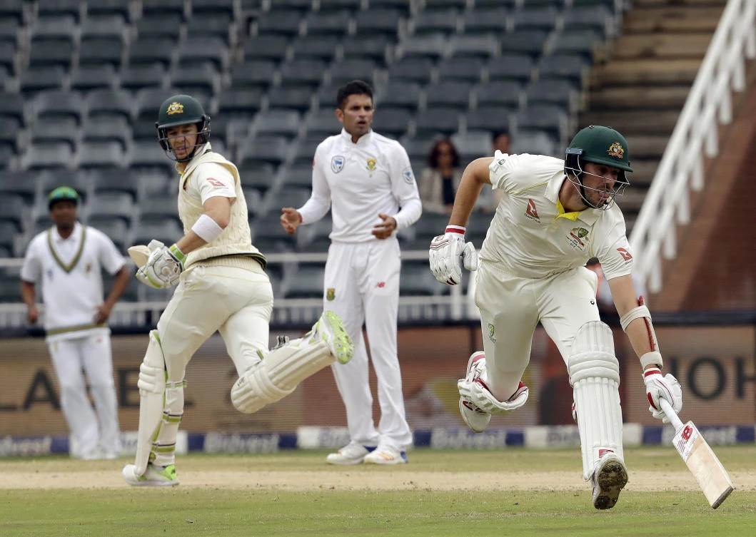 Australia's batsman Pat Cummins, right, avoids a run out as teammates Tim Paine, left, watches on during day three of the fourth match between South Africa and Australia at the Wanderers stadium in Johannesburg, South Africa, Sunday, April 1, 2018. (AP)
