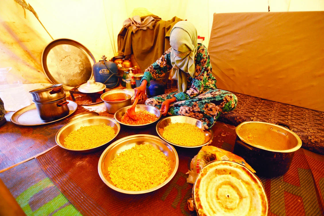 A woman displaced from the town of Tawergha prepares food at a camp in the Garart Al-Gatef, Libya. (File/Reuters)