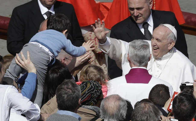 Pope Francis salutes a child after leading the Easter Mass at the Vatican on Sunday. (AP)