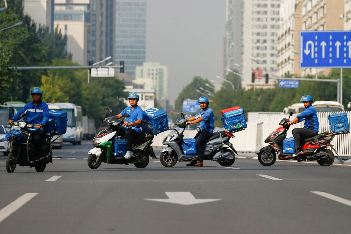 HUNGRY: Drivers of the food delivery service Ele.me before their morning shift in Beijing. (Reuters)