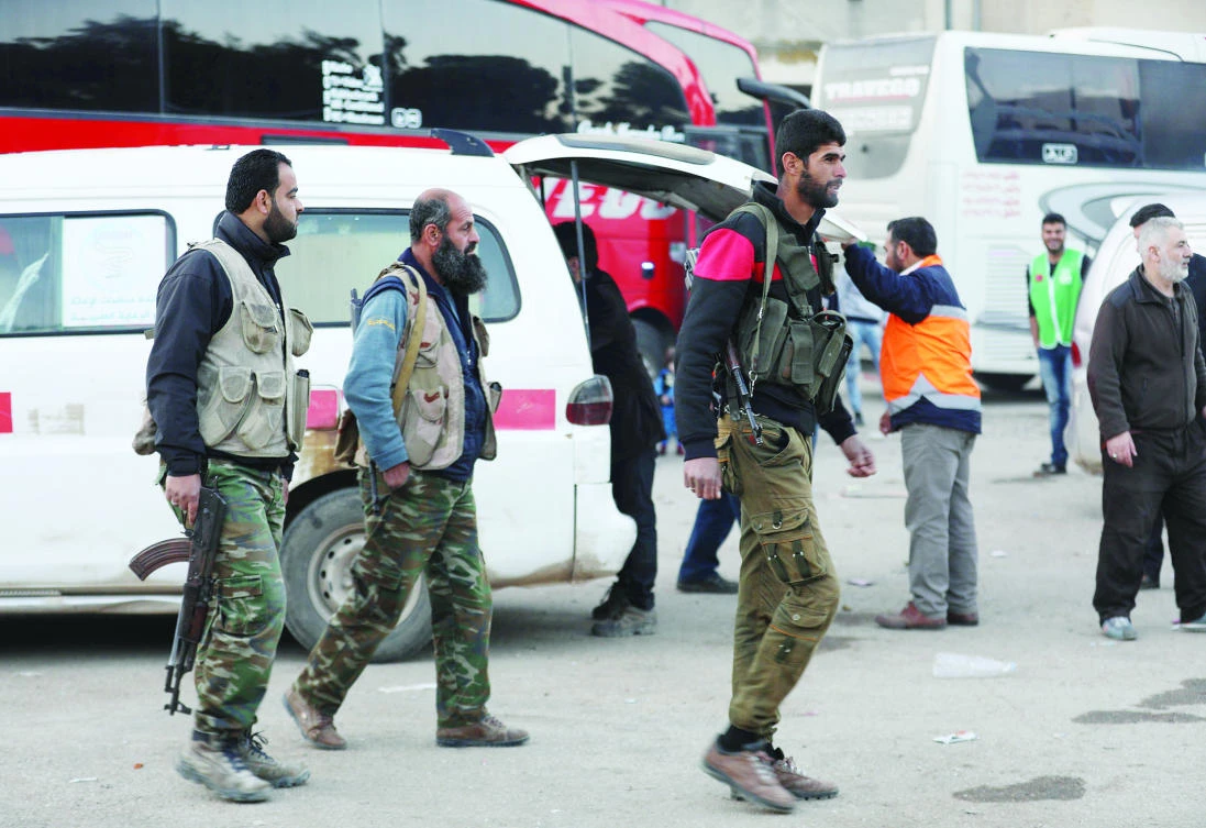 Civilians and fighters arrive in Qalaat Al-Madiq after being evacuated from the Eastern Ghouta town of Douma. (AFP)