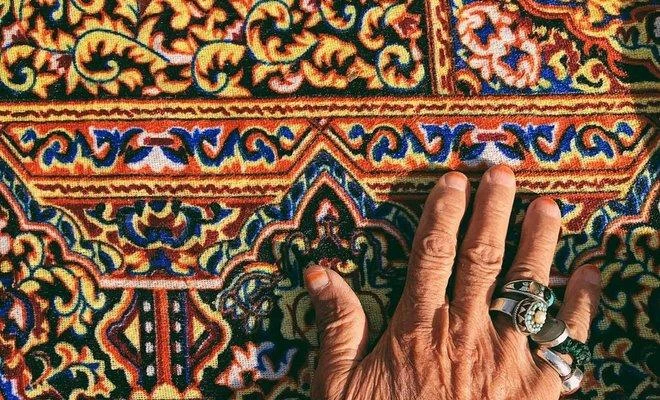 An old man puts his hand on a carpet. Silver rings and henna were part of the Saudi traditions – Nasir Al-Nasir. (Supplied)