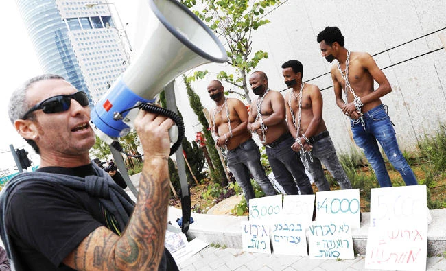 African migrants and Israelis demonstrate in the city of Tel Aviv on April 3, 2018, against the Israeli government's policy to forcibly deport African refugees and asylum seekers. (AFP)