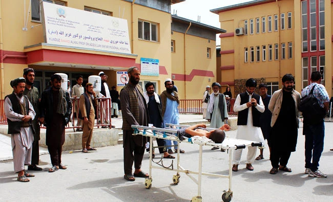 An injured Afghan boy lays on a stretcher outside a hospital in Kunduz on April 3, 2018, a day after an airstrike on a religious school. (AFP)